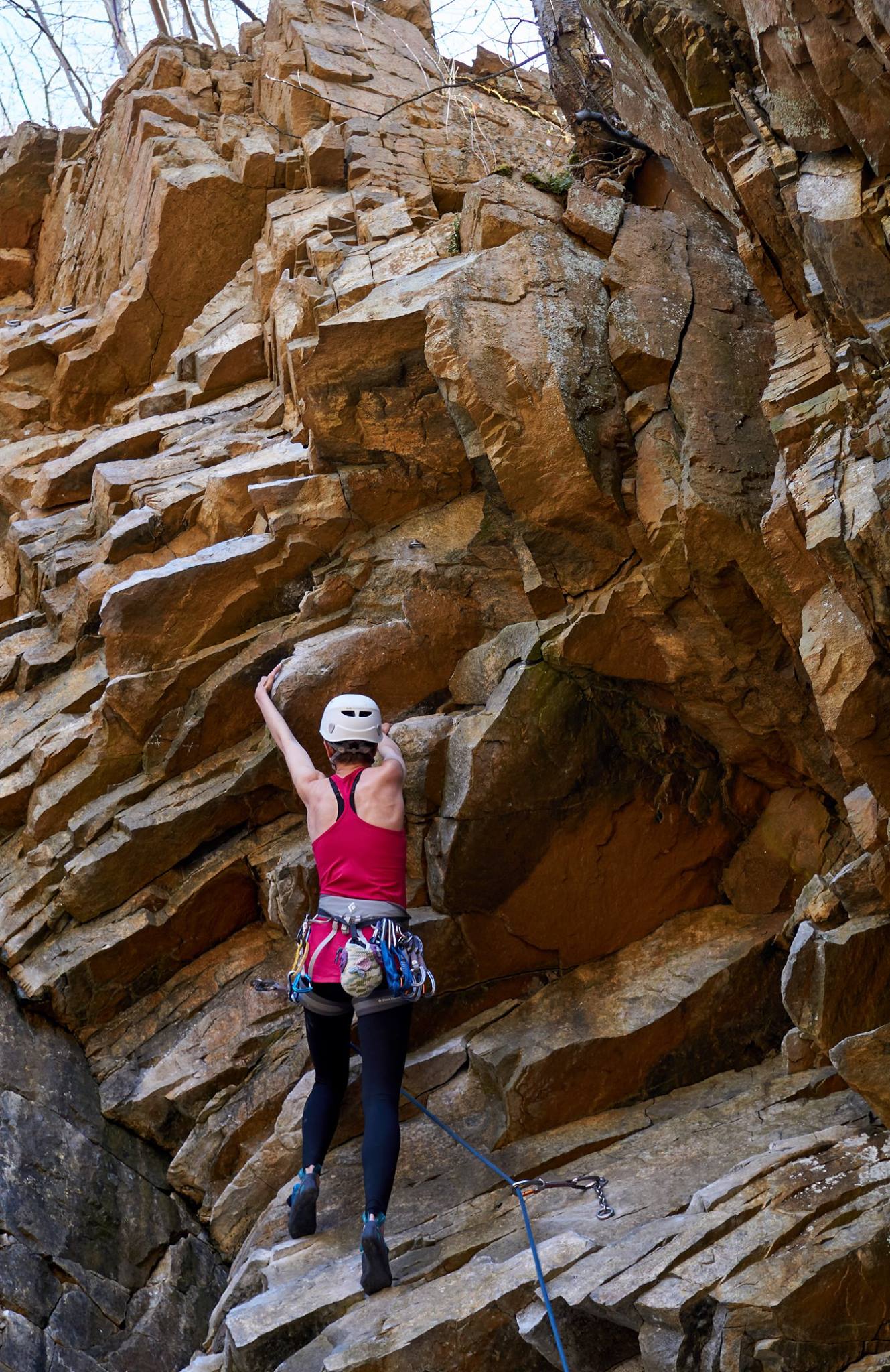 Rebecca climbing a jagged steep rock climb.