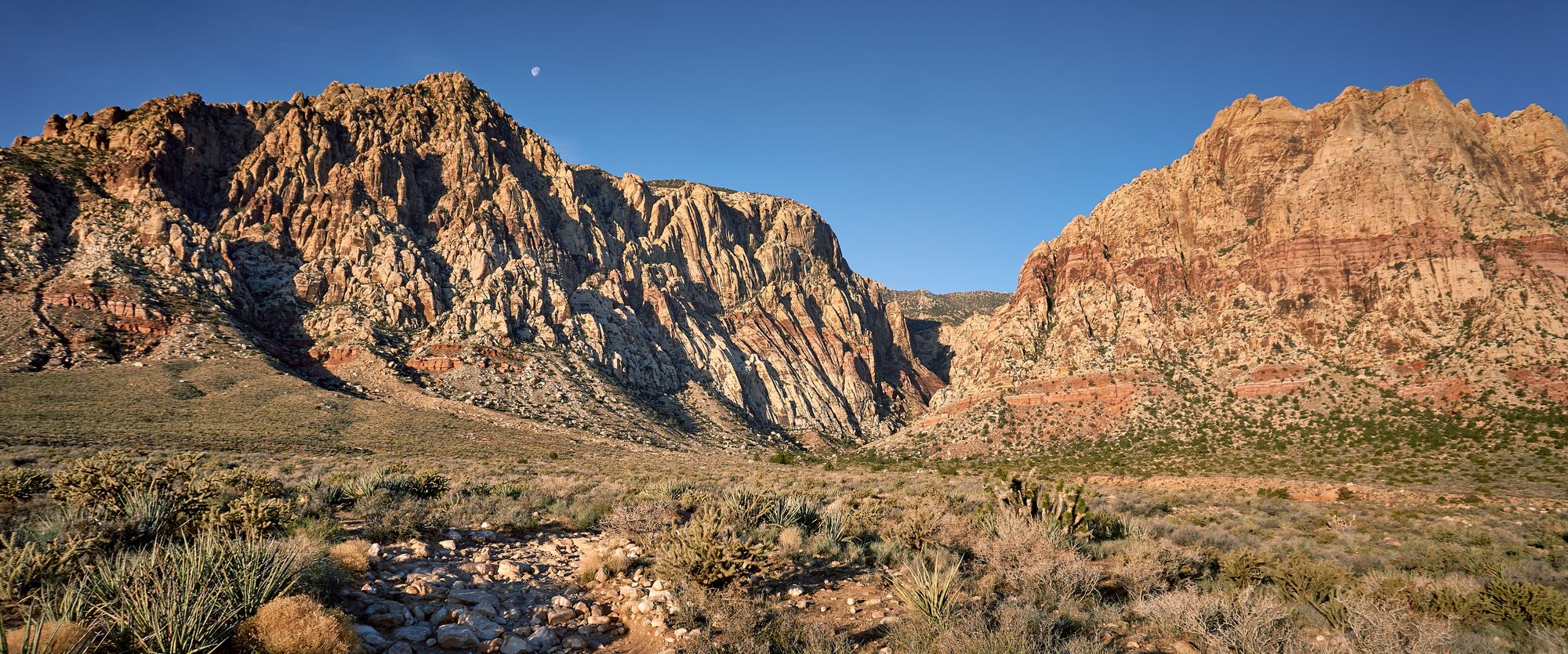 Landscape view of red rocks canyon. Center is a valley where hikers can traverse.