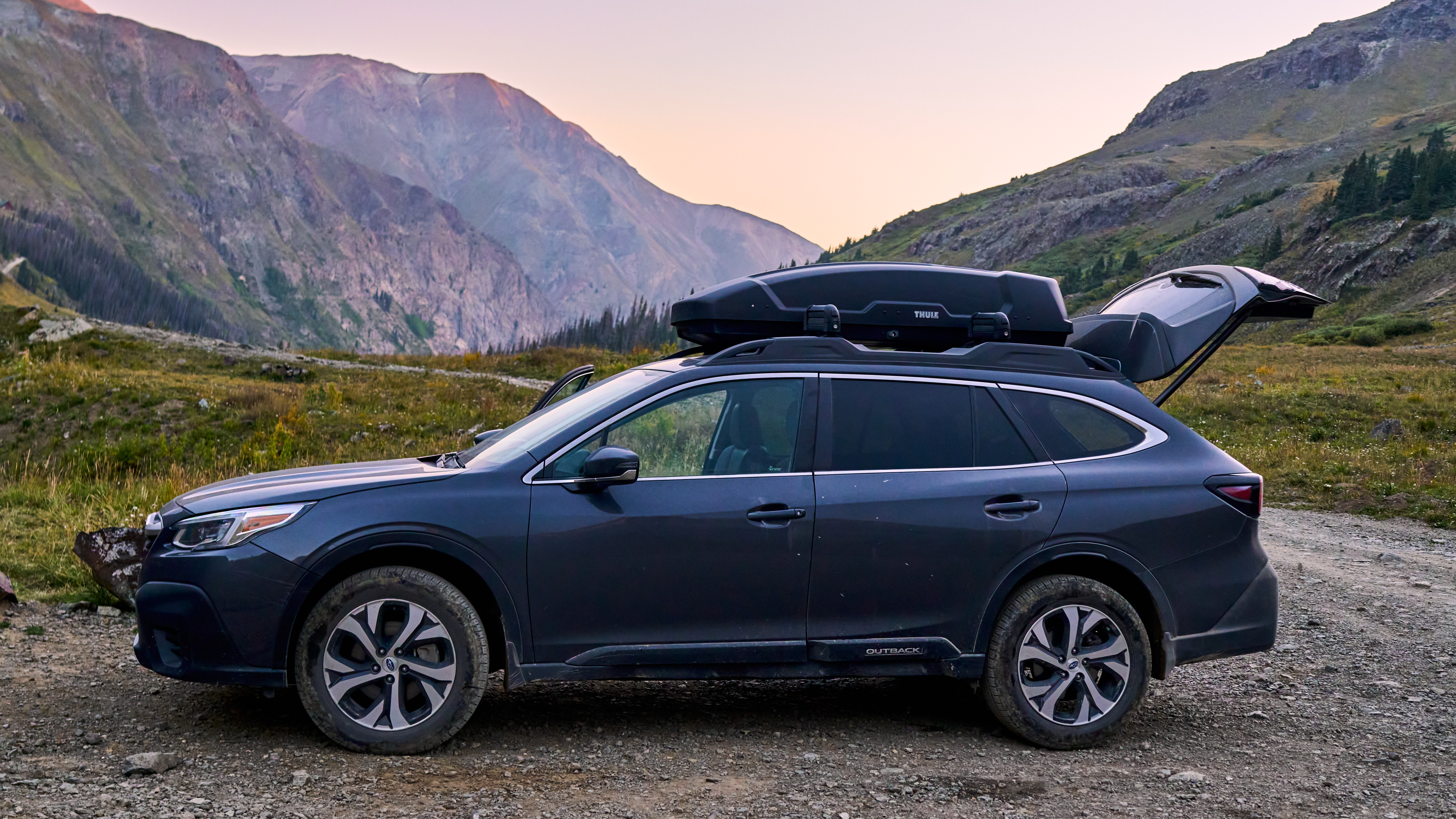 Subaru Outback parked at the trailhead with its hatch open.