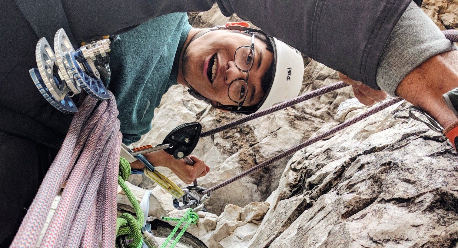 Me looking down while rock climbing with a bunch of rope and gear around